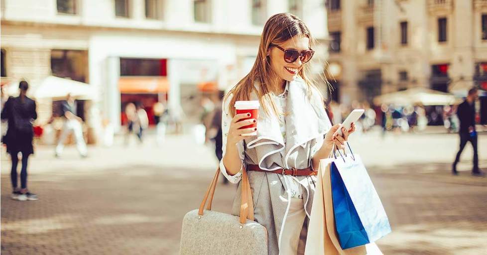 Happy-woman-reading-smartphone-and-shopping
